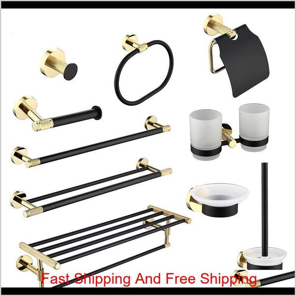 Black bathroom hardware set featuring gold towel rail, robe hook, bar rack, tissue holder, toothbrush stand, and brass shelf