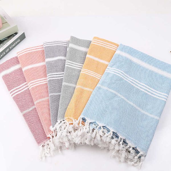 Striped cotton Turkish sports towel for women, featuring tassels, ideal for travel, gym, camping, sauna, beach, pool, and as a soft, absorbent blanket